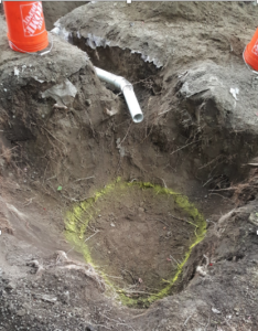 An inlet pipe hangs over an excavated bottom area.